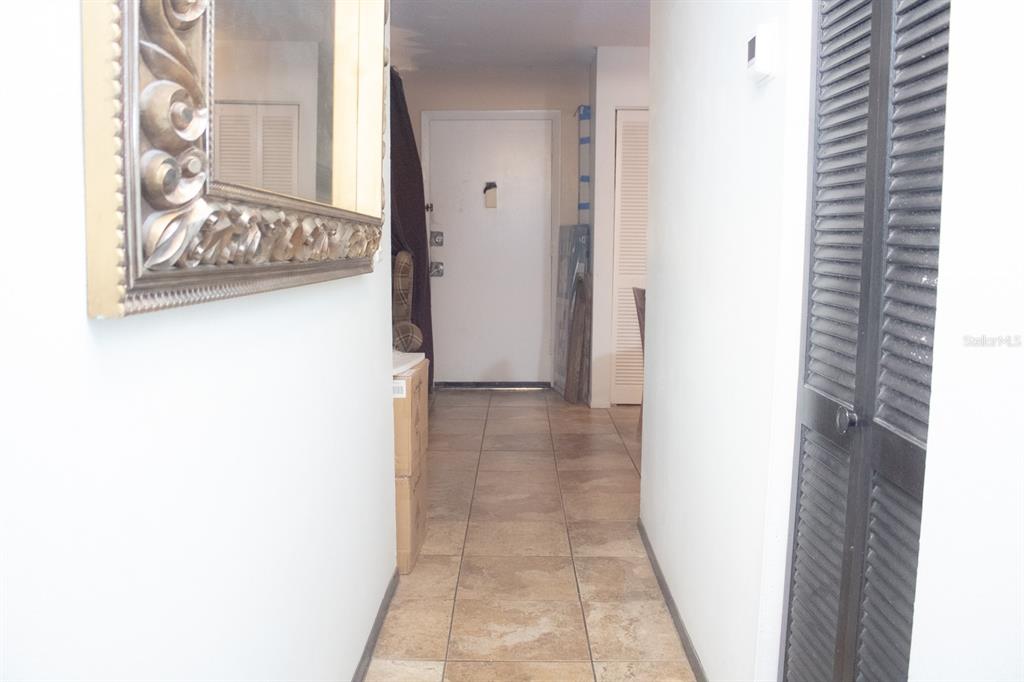 A tiled hallway leads to a white front door with a mirror on the left — 922 LAKE DESTINY ROAD UNIT H, ALTAMONTE SPRINGS, FL