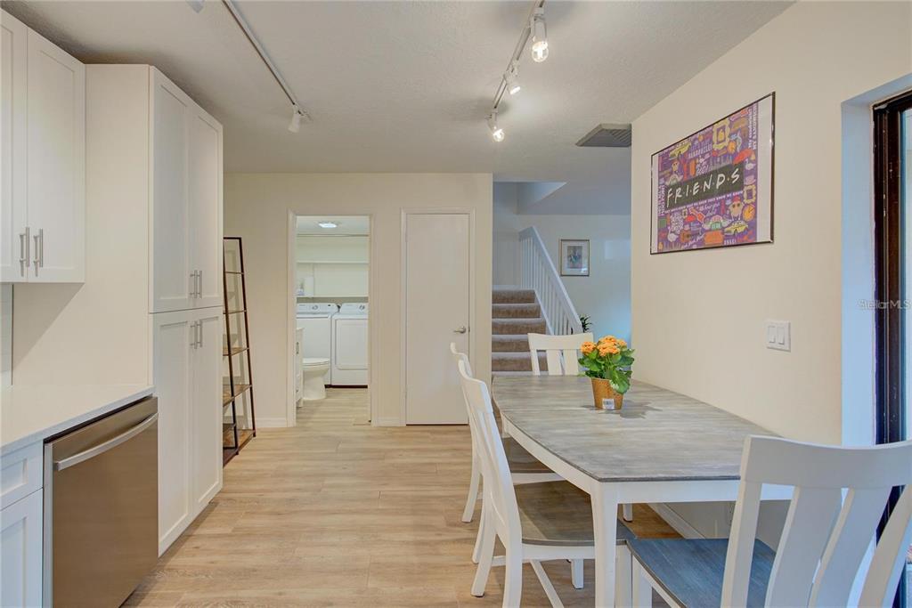 A dining area with a grey table and white chairs sits adjacent to a kitchen — 2612 2ND COURT, PALM HARBOR, FL