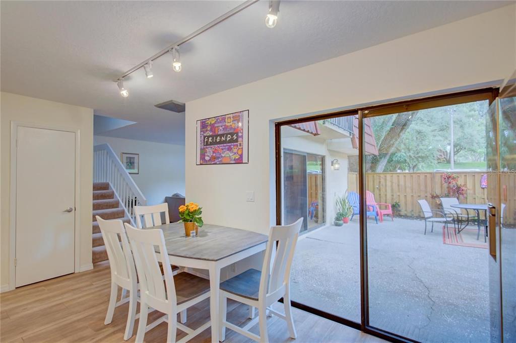 A dining area with a white table, four chairs, track lighting, and sliding glass patio doors — 2612 2ND COURT, PALM HARBOR, FL