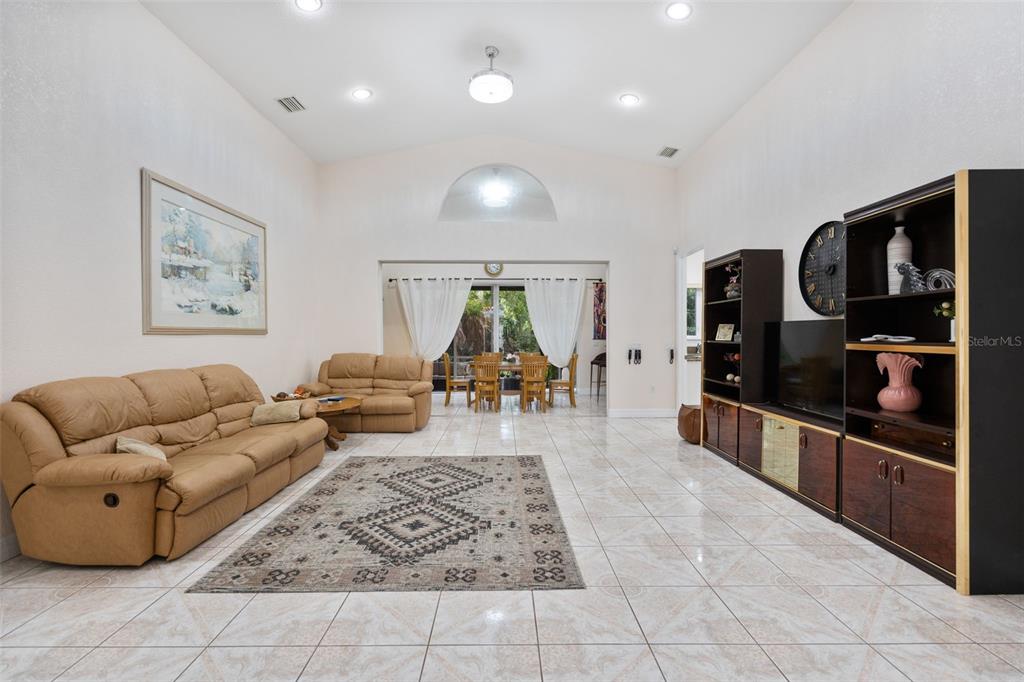A spacious living room features tiled floors, vaulted ceilings, and a large area rug — 333 ORDUNA DRIVE, NORTH PORT, FL