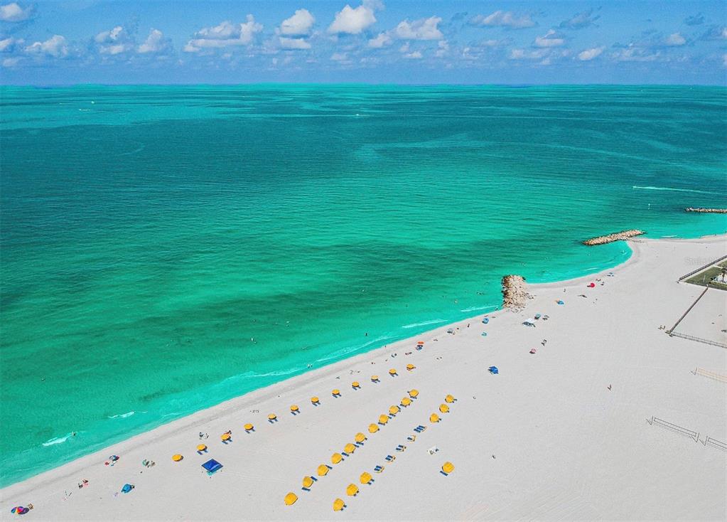 An aerial view of a white sand beach with yellow umbrellas and turquoise ocean water — 6800 SUNSET WAY UNIT 908, ST PETE BEACH, FL
