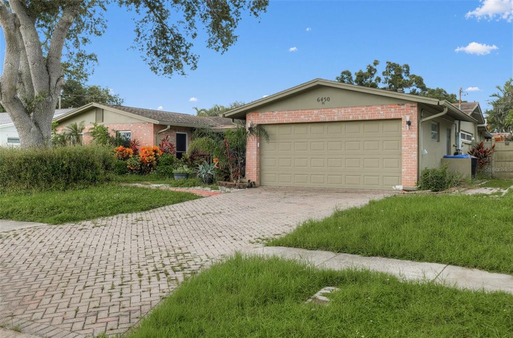 A single-story house with a brick facade, a two-car garage, and a paved driveway — 6450 31ST TERRACE N, ST PETERSBURG, FL