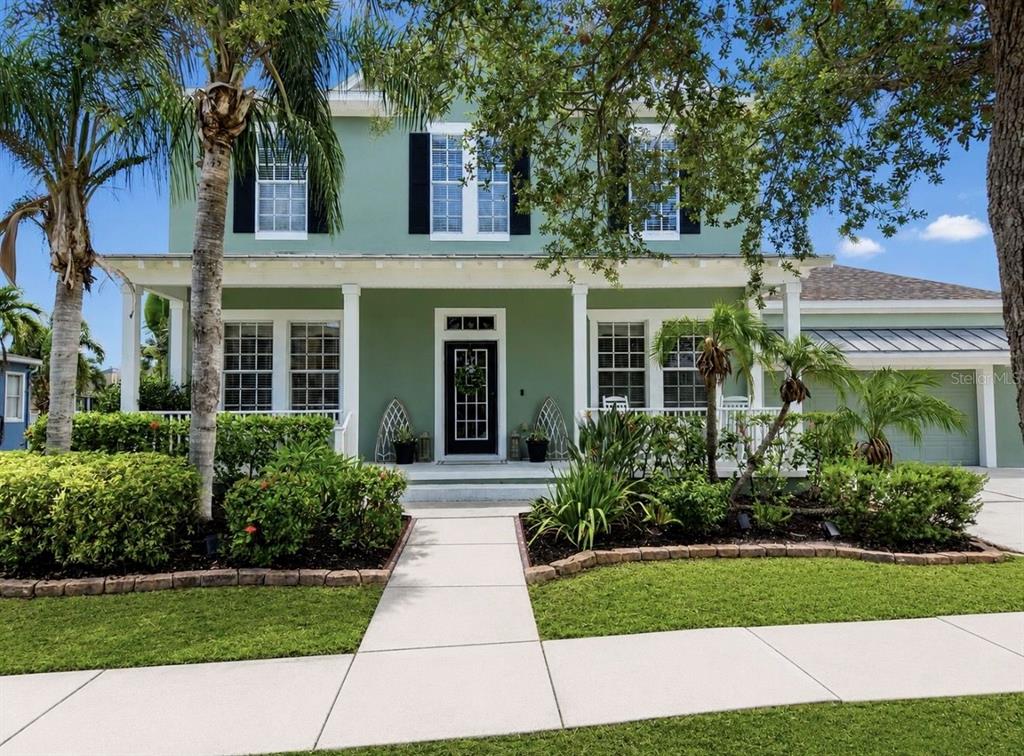 An aerial view of a green two-story house with a lawn and a canal — 5709 SEA TROUT PLACE, APOLLO BEACH, FL
