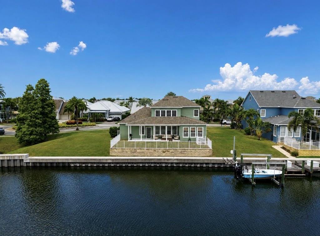 An aerial view of a green two-story house with a backyard facing a canal — 5709 SEA TROUT PLACE, APOLLO BEACH, FL