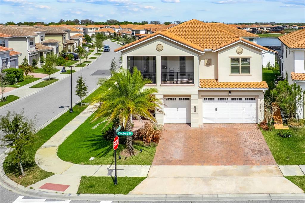 A two-story suburban house with a tiled roof, two-car garage, and a second-floor balcony — 8148 CLEOBURY DRIVE, ORLANDO, FL