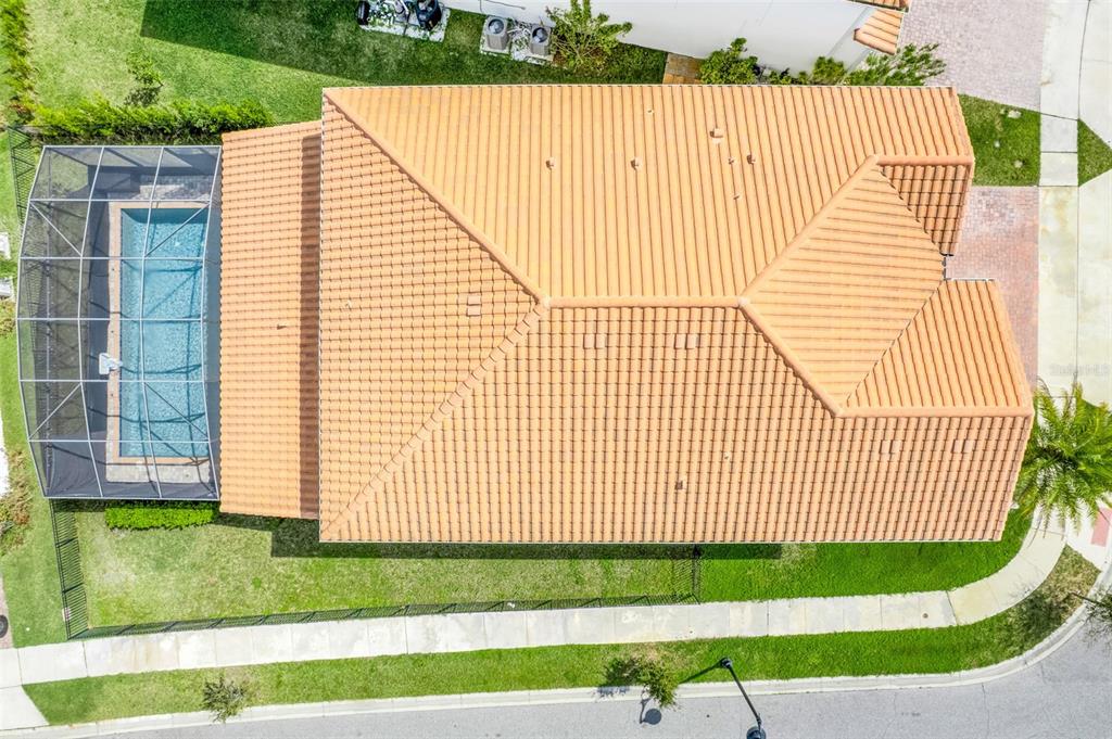 An aerial view shows a house with a tiled roof, a screened-in pool, and landscaping — 8148 CLEOBURY DRIVE, ORLANDO, FL