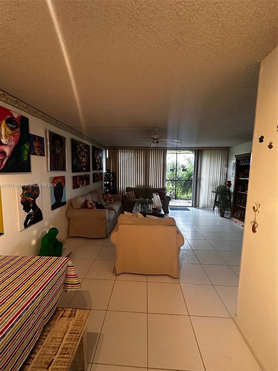 A living room features white tile floors, a beige sofa, and several framed portraits — 3771 Environ Blvd # 151, Lauderhill FL 33319, LAUDERHILL, FL