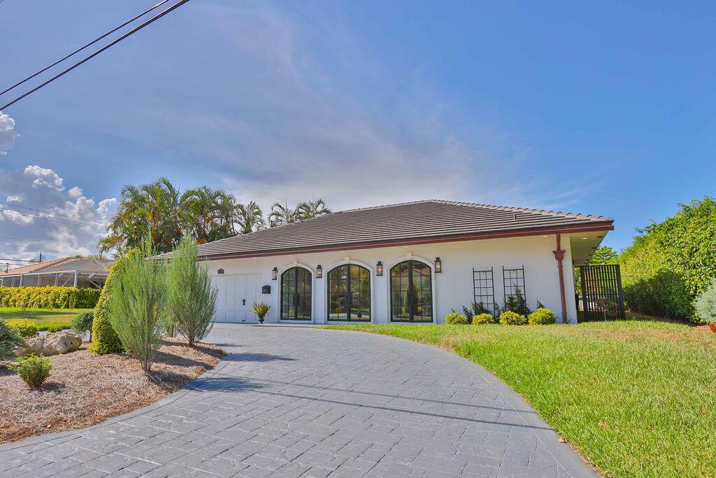 A single-story white house with arched windows and a gray stone driveway — 713 Forsyth Street, Boca Raton FL 33487, BOCA RATON, FL