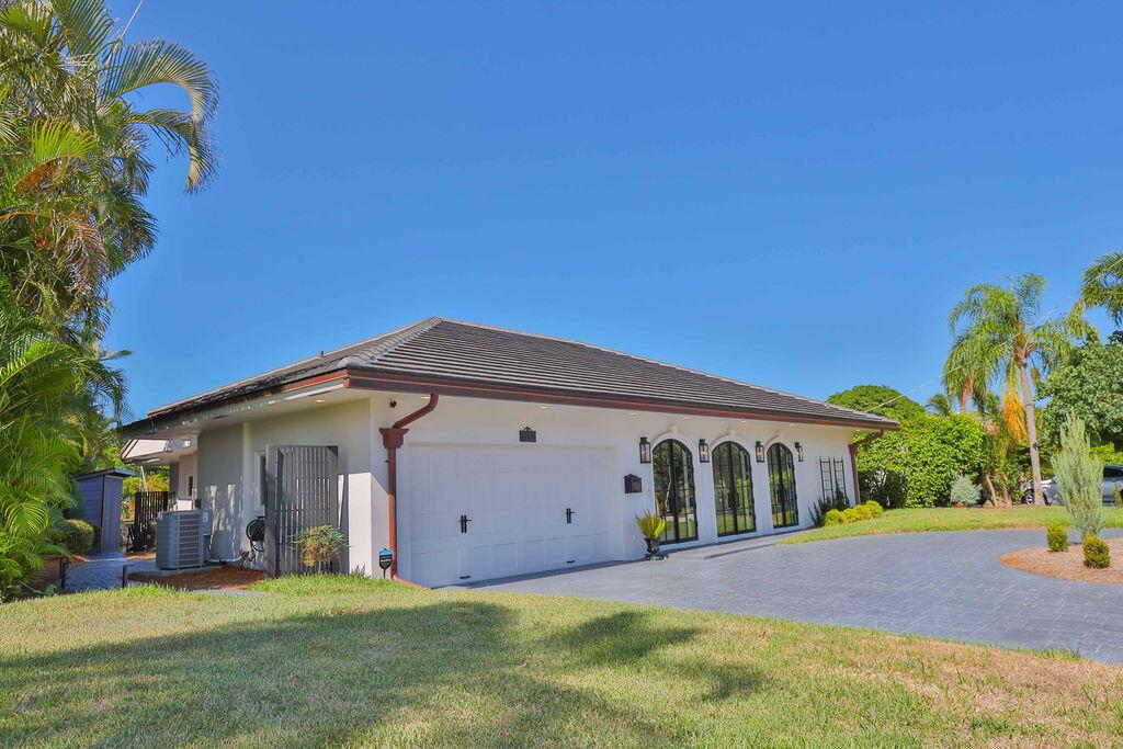 A white single-story house with a two-car garage and arched windows under a dark roof — 713 Forsyth Street, Boca Raton FL 33487, BOCA RATON, FL