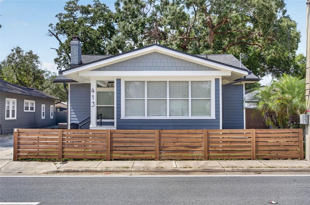 A blue house with a wooden horizontal fence and a large front window — 413 W PRINCETON STREET, ORLANDO, FL