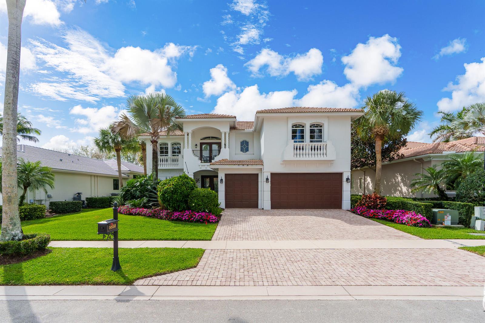 A two-story stucco house with a brick driveway, brown garage doors, and palm trees — 8850 Valhalla Drive, Delray Beach FL 33446, DELRAY BEACH, FL