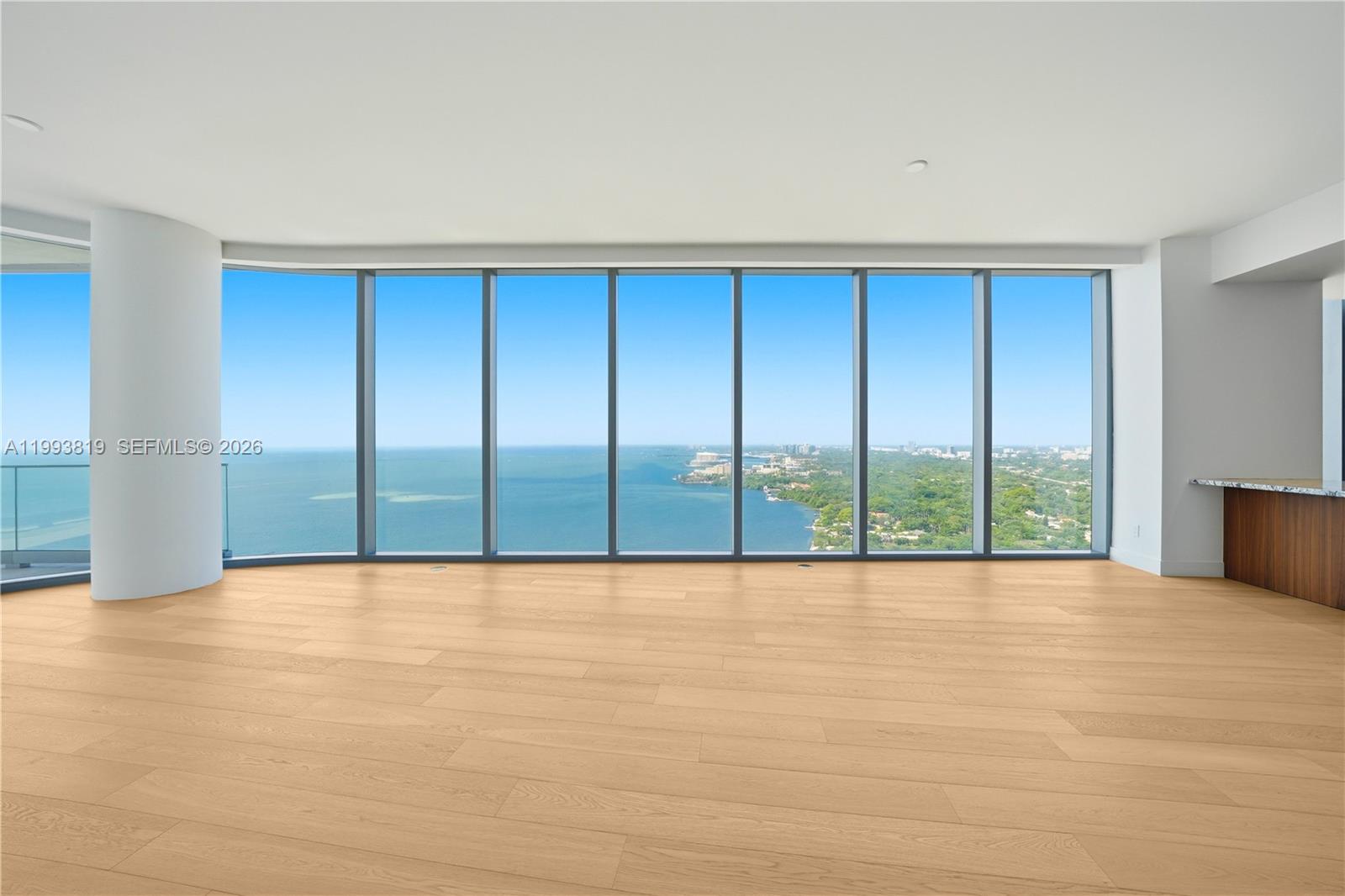 An empty room with light wood floors and floor-to-ceiling windows overlooking the ocean — 175 SE 25th Road # 3102, Miami FL 33129, MIAMI, FL