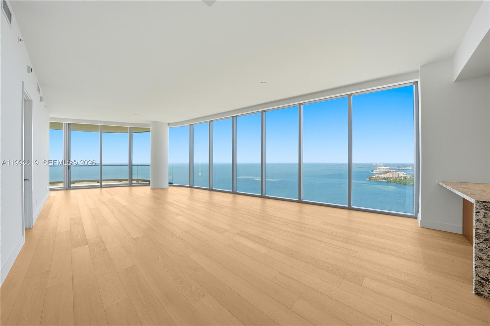 An empty room features light wood flooring, white walls, and floor-to-ceiling windows overlooking the ocean — 175 SE 25th Road # 3102, Miami FL 33129, MIAMI, FL