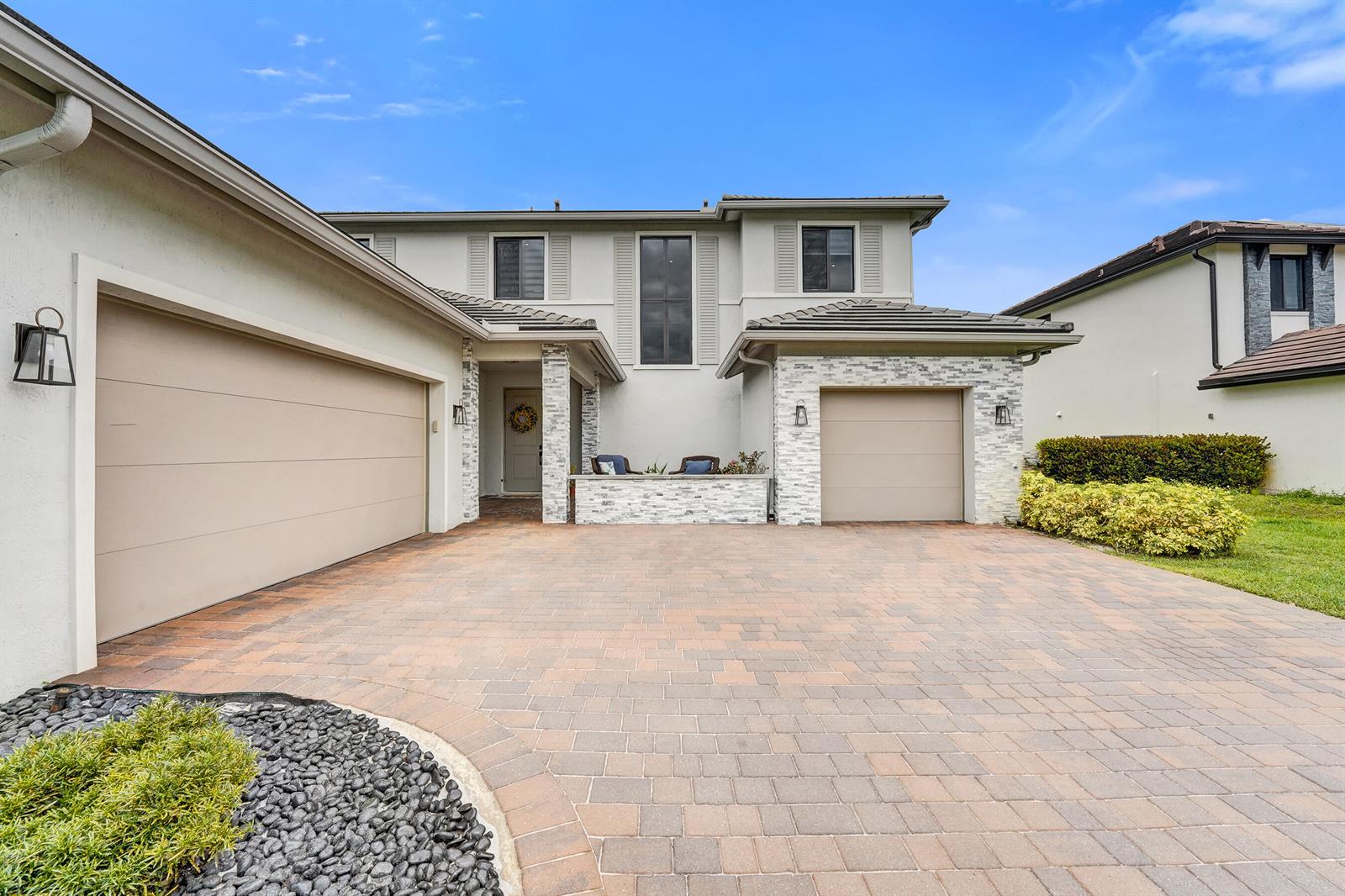A paved patio area features two wicker chairs, potted plants, and a light-colored exterior wall — 13025 Addilyn Court, Davie FL 33325, DAVIE, FL