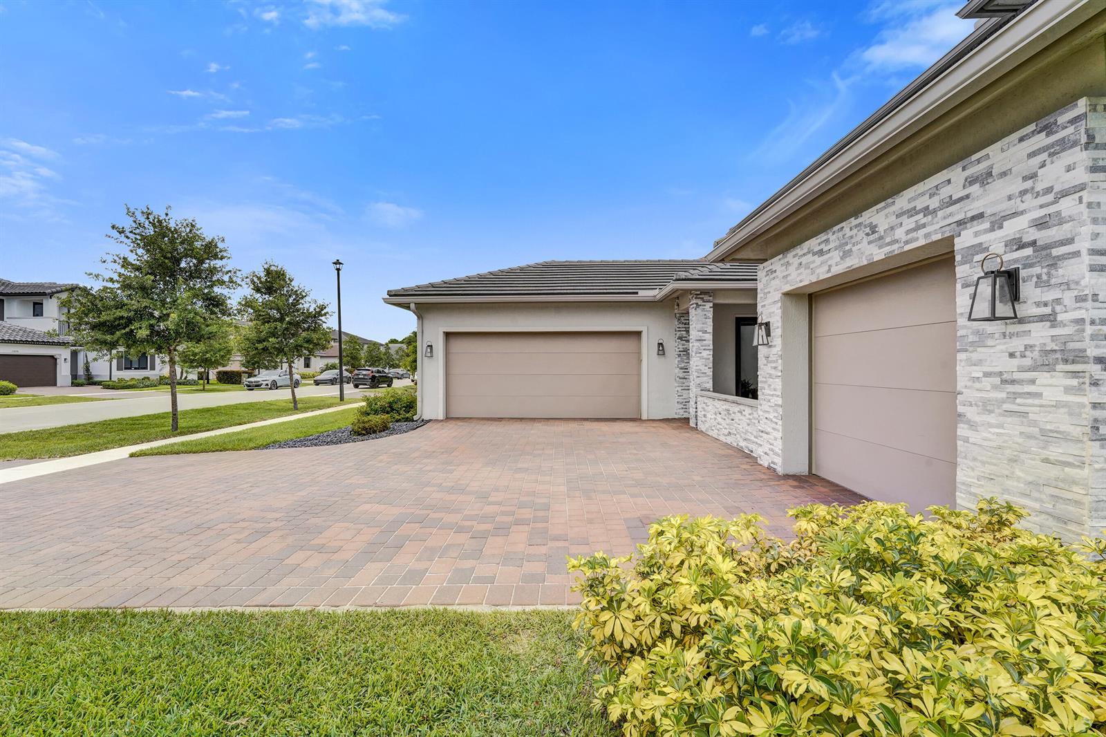 A covered patio features brick pavers, two wicker chairs, potted plants, and a front door — 13025 Addilyn Court, Davie FL 33325, DAVIE, FL
