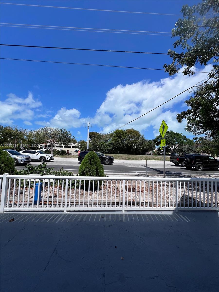 A view from a balcony overlooking a street with parked cars and a pedestrian sign — 91461 Overseas Hwy, Tavernier FL 33070, TAVERNIER, FL