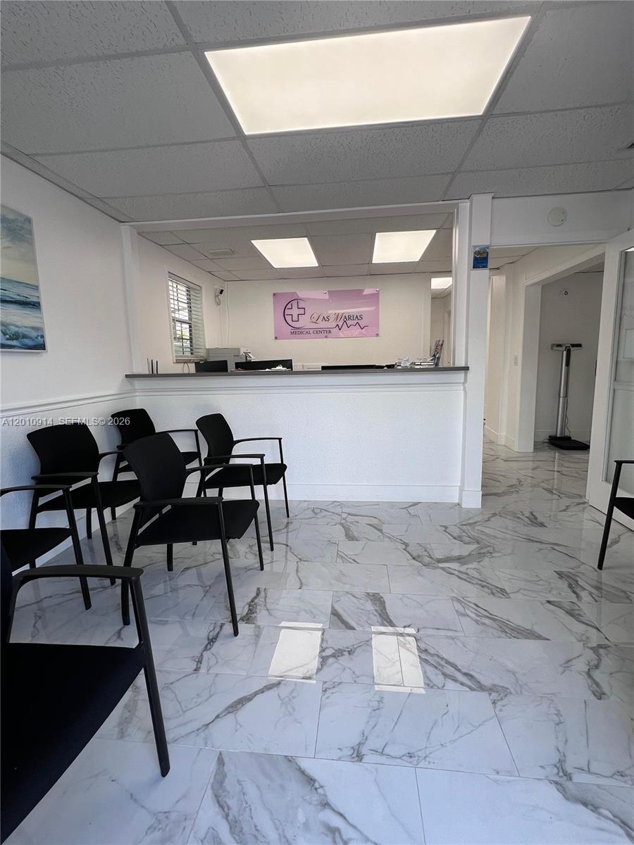A medical office waiting room features black chairs, a reception desk, and white marble-patterned flooring — 91461 Overseas Hwy, Tavernier FL 33070, TAVERNIER, FL