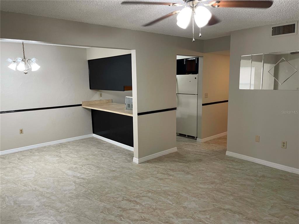 A dining area with tile flooring, a breakfast bar, and a ceiling fan — 1000 LAKE OF THE WOODS BOULEVARD UNIT F106, FERN PARK, FL