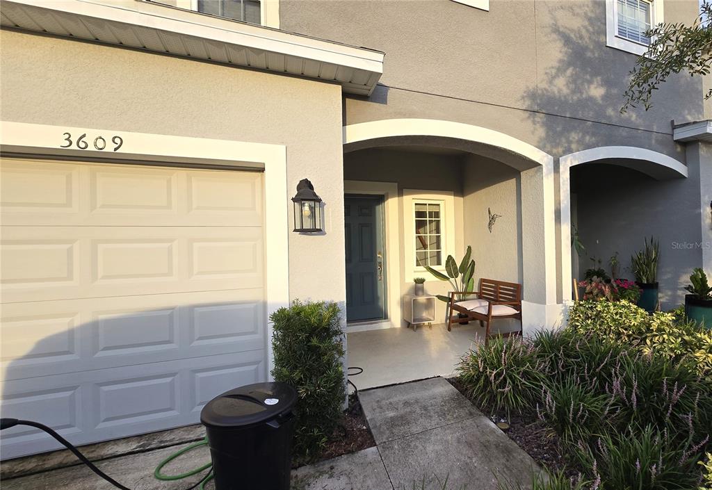 A gray two-story house exterior features a garage, a covered entryway, and a small porch — 3609 ANIBAL STREET, KISSIMMEE, FL