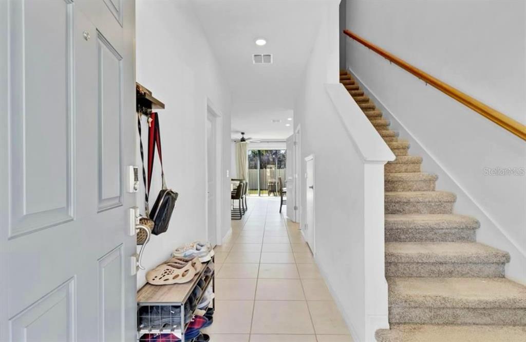 An entryway with a staircase, tile flooring, and a view leading toward the back — 3609 ANIBAL STREET, KISSIMMEE, FL