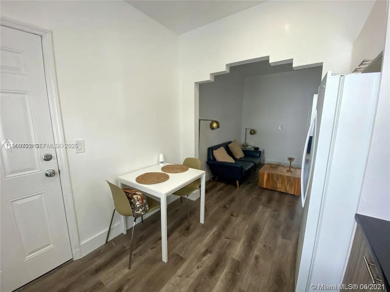 A dining area with a small table and chairs opens into a living room — 8415 Harding Ave # 5, Miami Beach FL 33141, MIAMI BEACH, FL