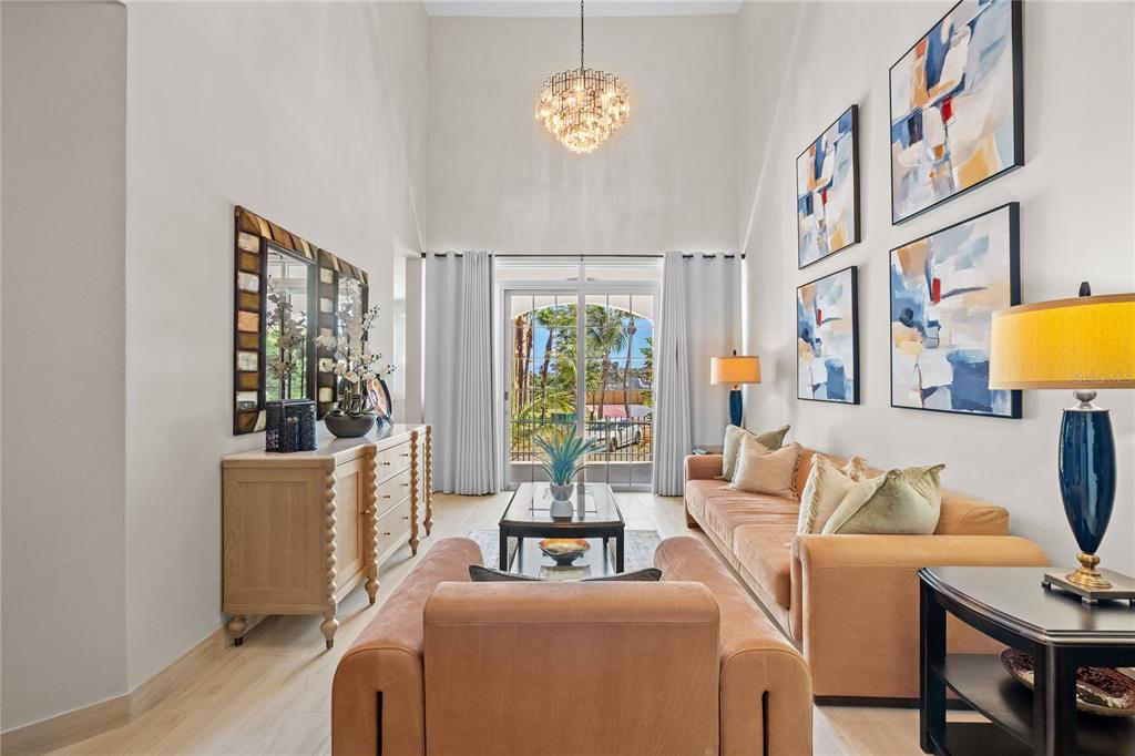 A living room features high ceilings, a chandelier, a sofa, and a glass sliding door — 6690 Rd. ROYAL PALM COND. UNIT D-101, VEGA ALTA, PR