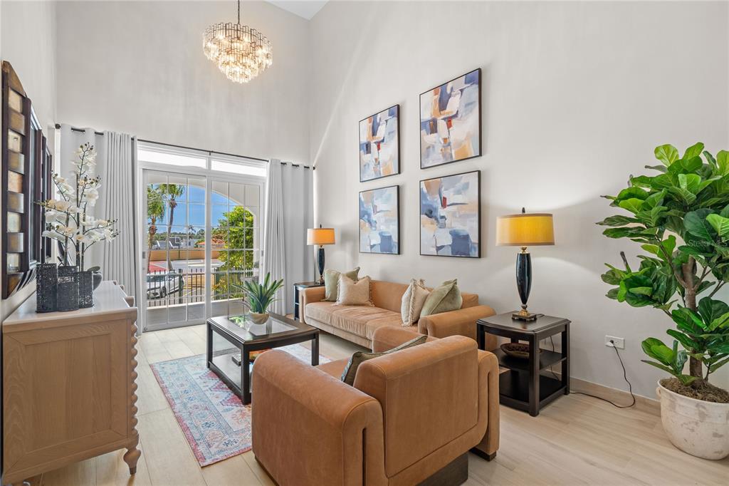 A living room features high ceilings, a chandelier, a sofa, an armchair, and sliding doors — 6690 Rd. ROYAL PALM COND. UNIT D-101, VEGA ALTA, PR