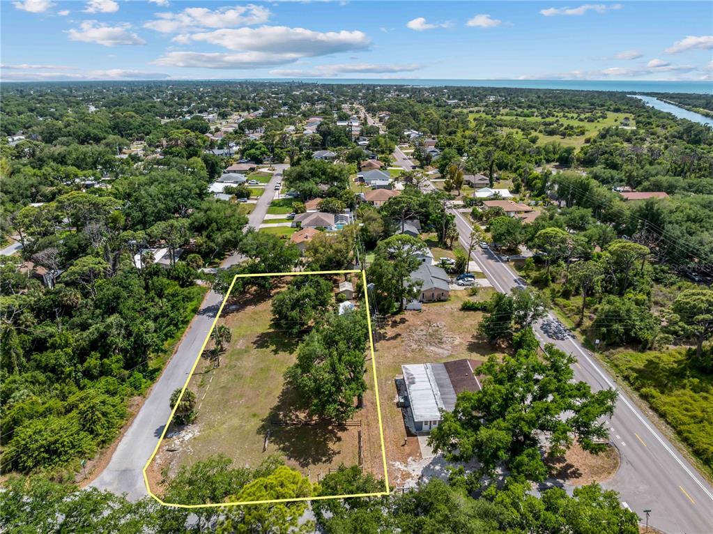An aerial view shows a vacant, rectangular lot outlined in yellow between two paved roads — DAWN DRIVE, VENICE, FL