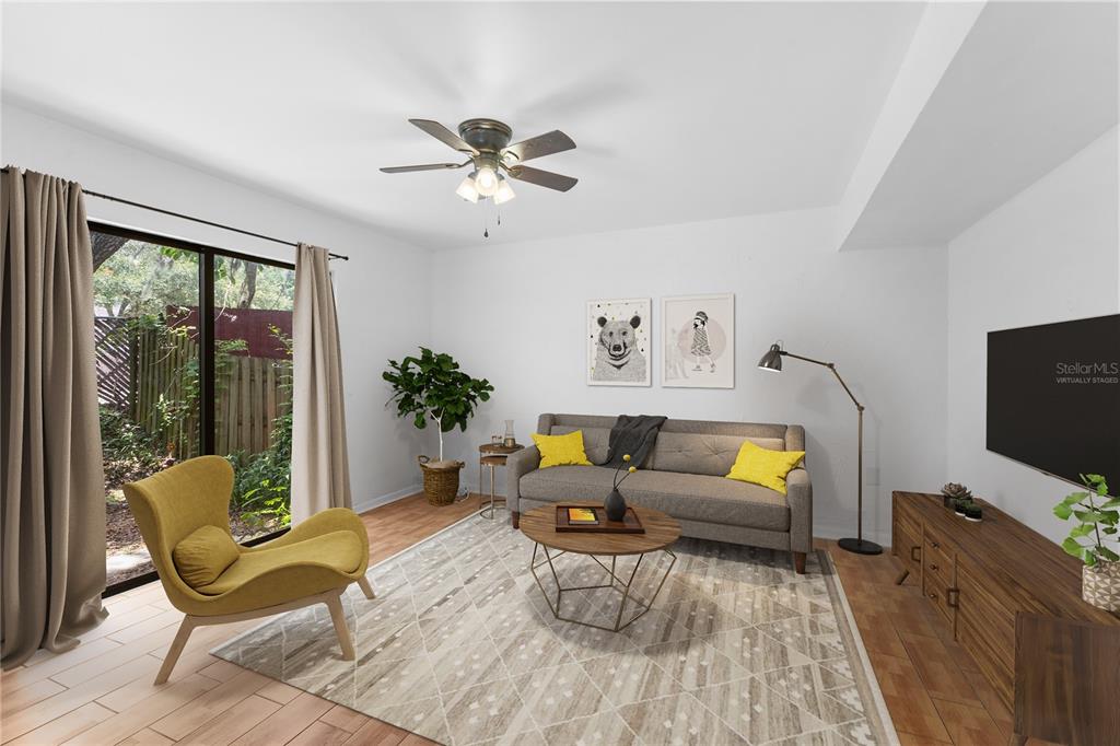 A living room features tile flooring, a gray sofa, a yellow armchair, and sliding glass doors — 5641 ASHLEY OAKS DRIVE UNIT 37, TAMPA, FL