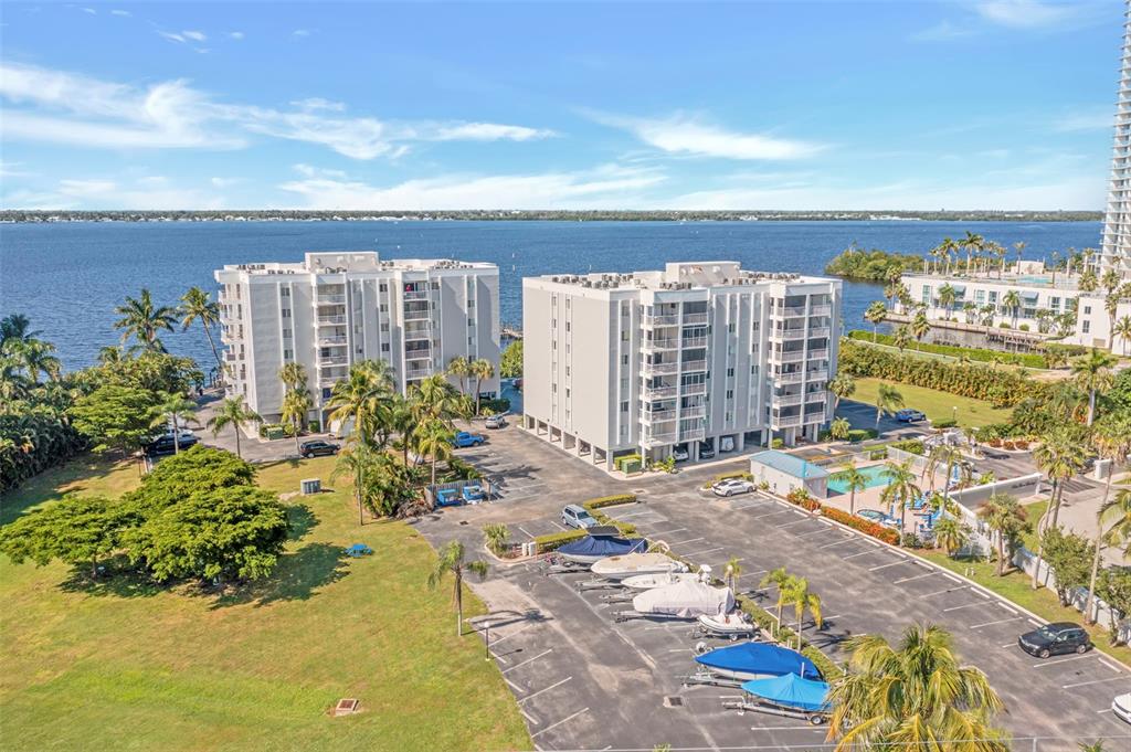 An aerial view of two apartment buildings with a parking lot, boat trailers, and water — 2875 PALM BEACH BOULEVARD UNIT 205, FORT MYERS, FL