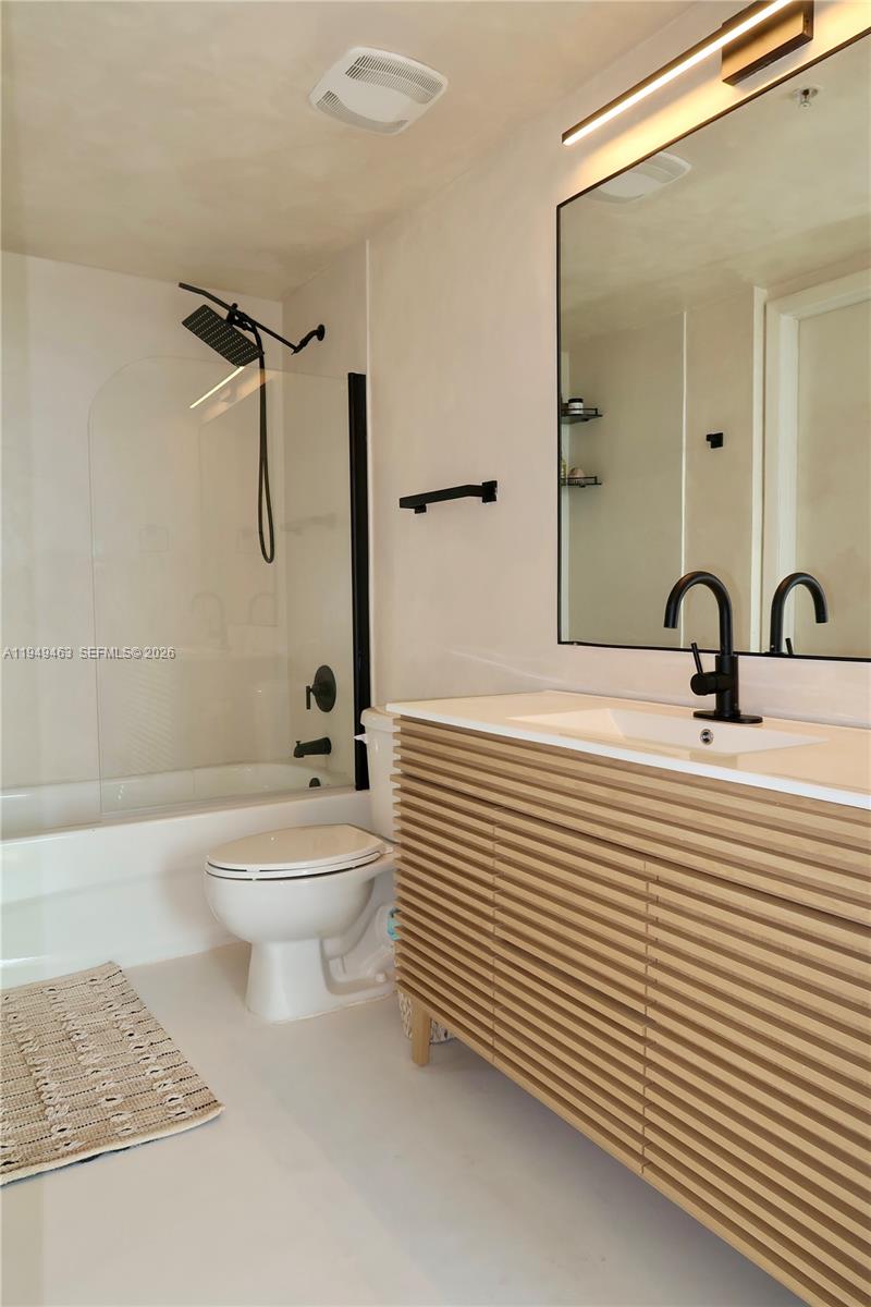 A modern bathroom features a slatted wood vanity, matte black fixtures, and a glass-enclosed tub — 1861 NW S River Dr # 2505, Miami FL 33125, MIAMI, FL