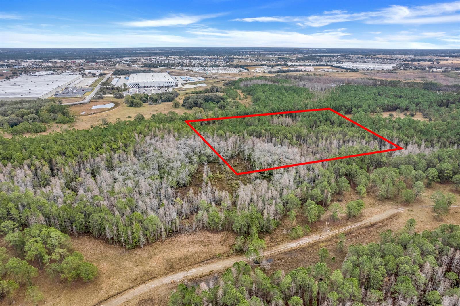 An aerial view shows a rectangular plot of land outlined in red amidst wooded terrain — 000 No Street, FL 33868, FL