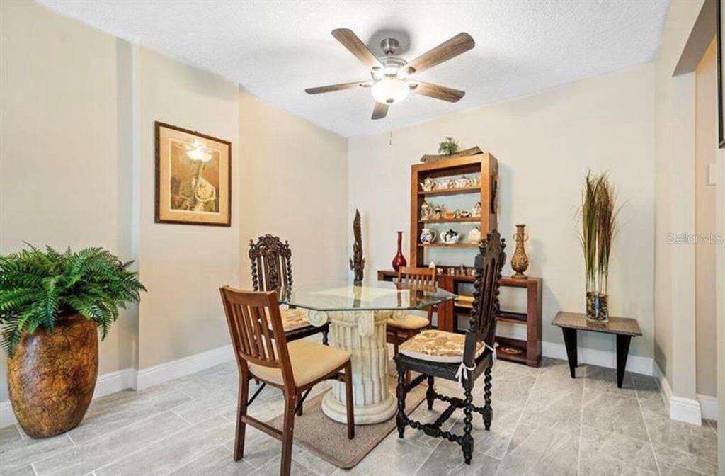 A dining room features a glass-topped table with a pedestal base, chairs, and a wooden hutch — 250 NE 20TH STREET UNIT 3030, BOCA RATON, FL