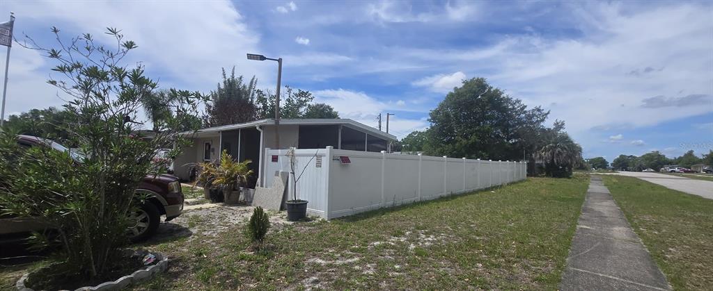 A white vinyl privacy fence encloses the side yard of a single-story home — 1222 STILLWATER AVENUE, DELTONA, FL