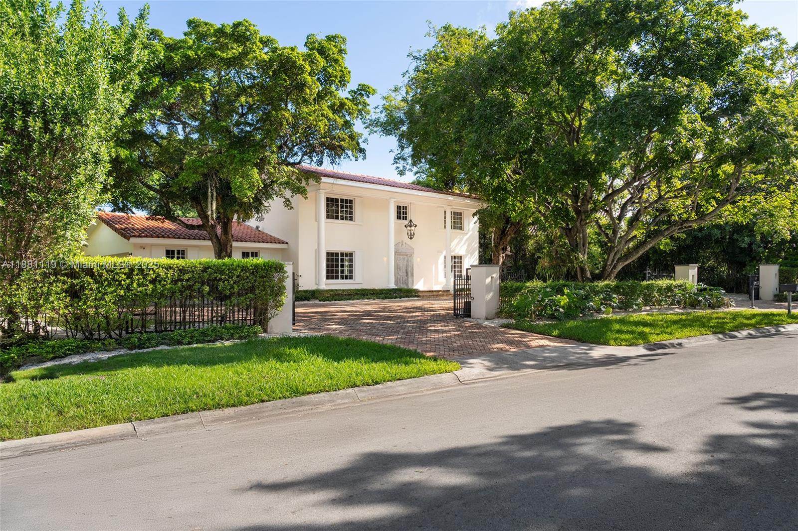 A two-story white house with a red tile roof sits behind a brick driveway — 575 Bay Point Rd, Miami FL 33137, MIAMI, FL