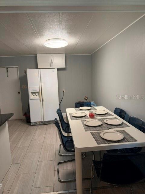 A dining area features a white table with six chairs, tiled floors, and a white refrigerator — 6907 GIBRALTAR ROAD, ORLANDO, FL