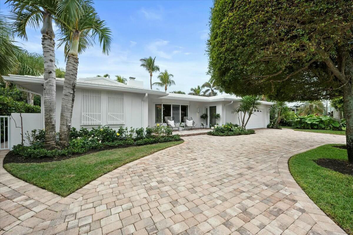 A single-story white house with a paver driveway and palm trees in the front yard — 232 Cove Place, Jupiter FL 33469, JUPITER, FL