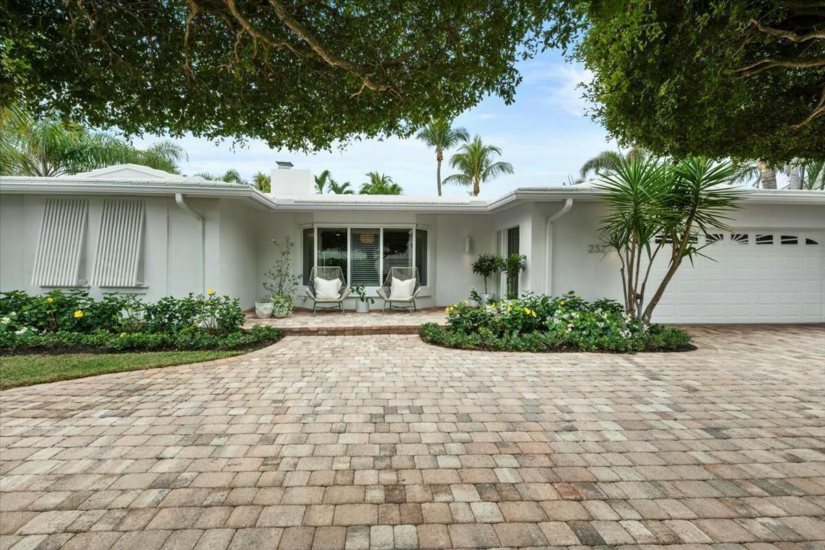A single-story white house with a paved driveway, a bay window, and two patio chairs — 232 Cove Place, Jupiter FL 33469, JUPITER, FL