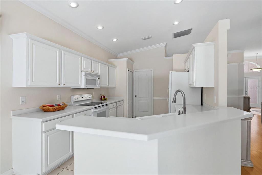 A kitchen with white cabinets, white countertops, and stainless steel appliances — 8492 IDLEWOOD COURT, LAKEWOOD RANCH, FL