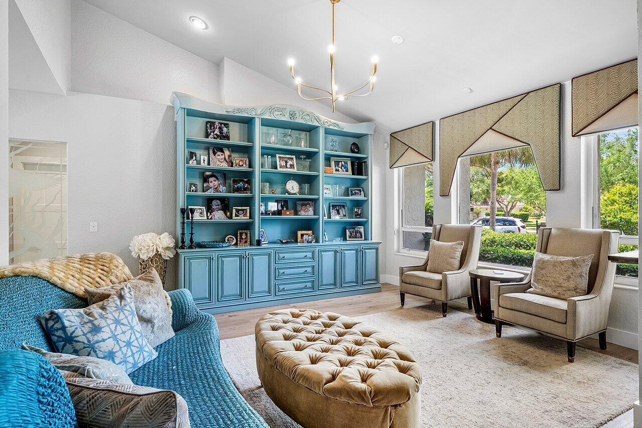 A living room features a large blue built-in bookshelf, a tufted ottoman, and two armchairs — 3010 Hampton Circle, Boca Raton FL 33434, BOCA RATON, FL