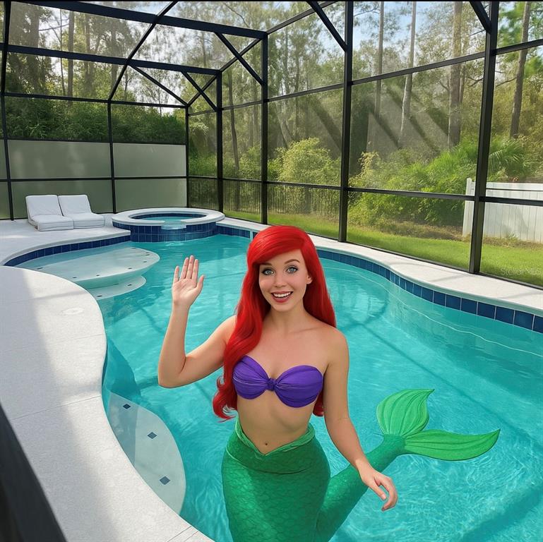 A woman dressed as a mermaid stands in a screened-in swimming pool with a hot tub — 1326 BUTTERFLY ORCHID ROAD, DAVENPORT, FL