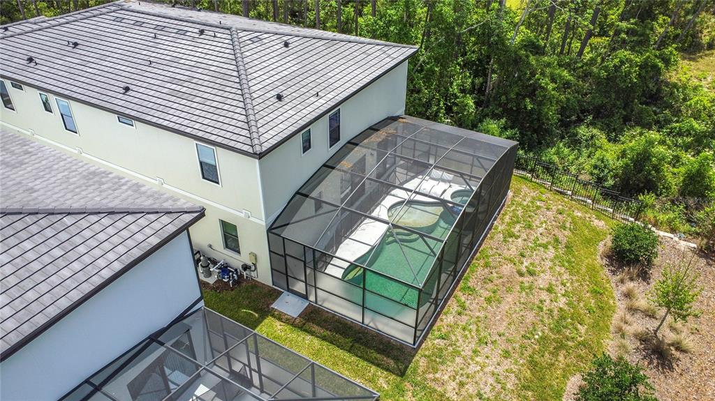 An aerial view shows a two-story house with a screened-in pool and patio area — 1326 BUTTERFLY ORCHID ROAD, DAVENPORT, FL