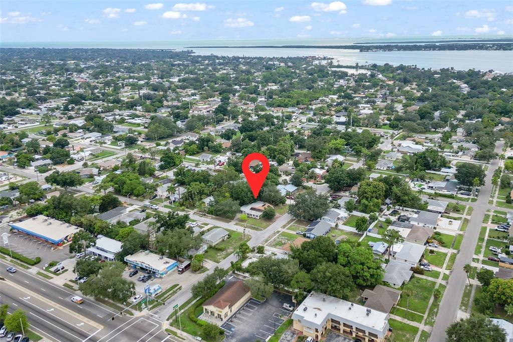 An aerial view shows a residential property marked with a red pin near a coastline — 302 51ST STREET W, BRADENTON, FL