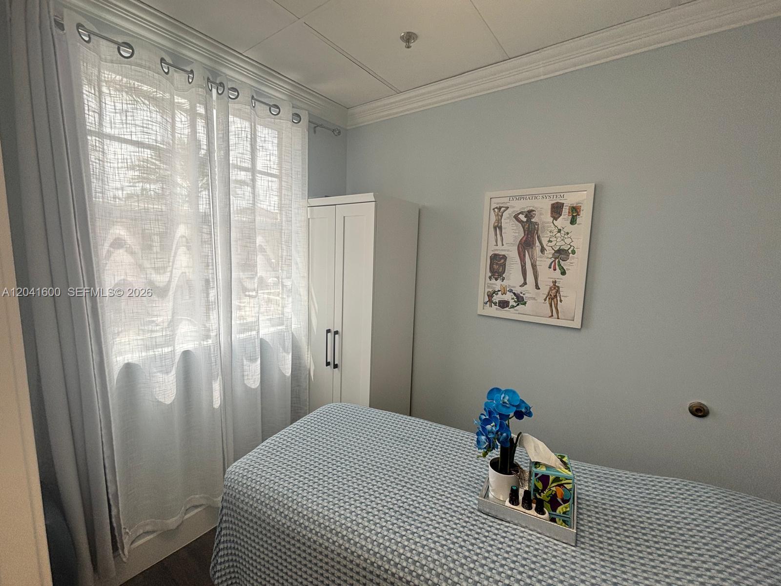 A treatment room features a massage table, a white cabinet, and a lymphatic system chart — WESTON, FL