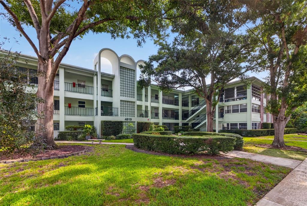 A three-story apartment building with a light green facade and a central decorative screen — 4819 8TH AVENUE N UNIT 201, ST PETERSBURG, FL