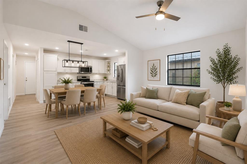 A bright open-concept living and dining area features light wood flooring and white cabinetry — 716 GROVE AVENUE, ORLANDO, FL