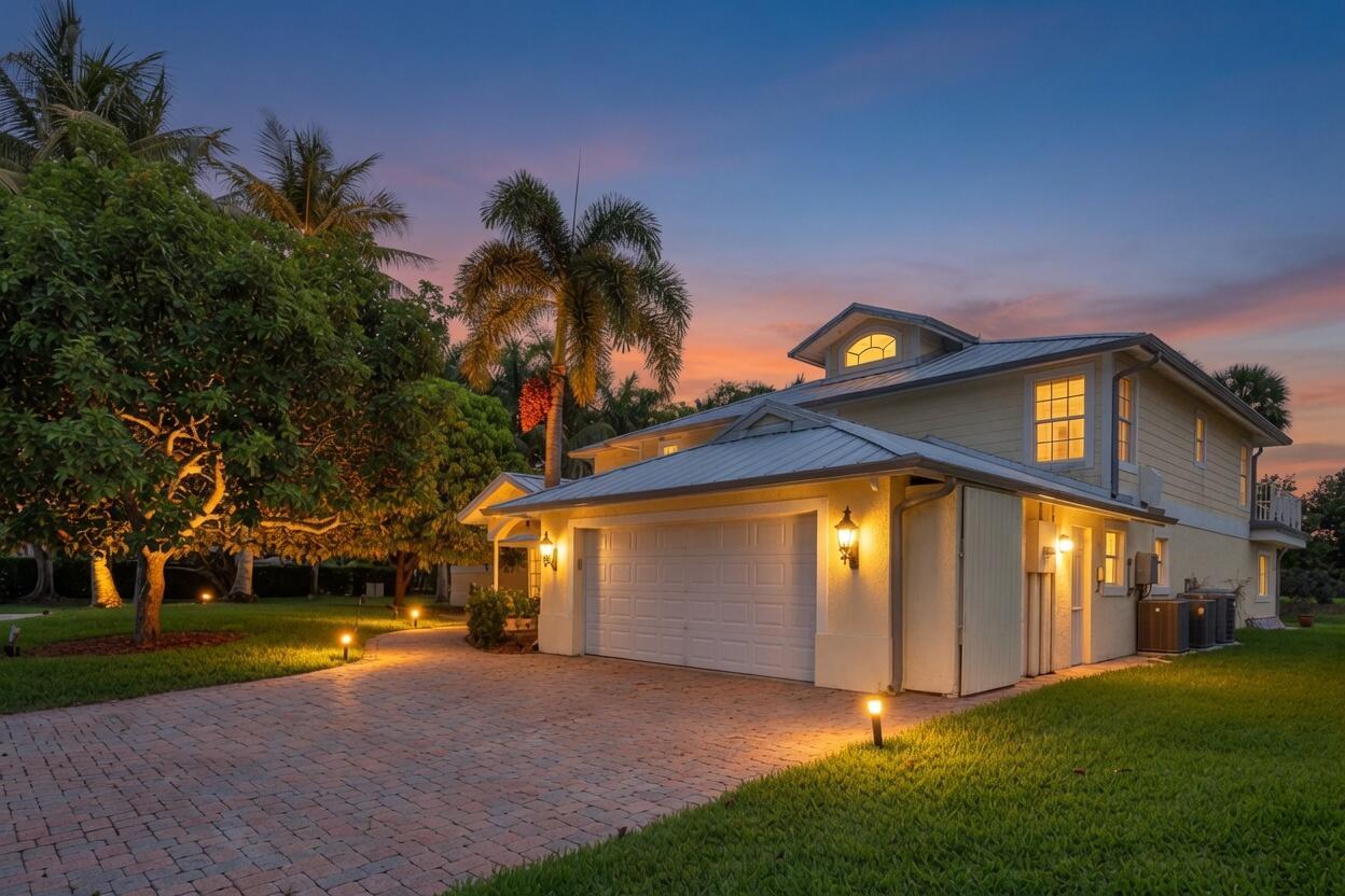A two-story house with a white garage, metal roof, and palm trees at sunset — 5844 Pinebrook Drive, Boca Raton FL 33433, BOCA RATON, FL