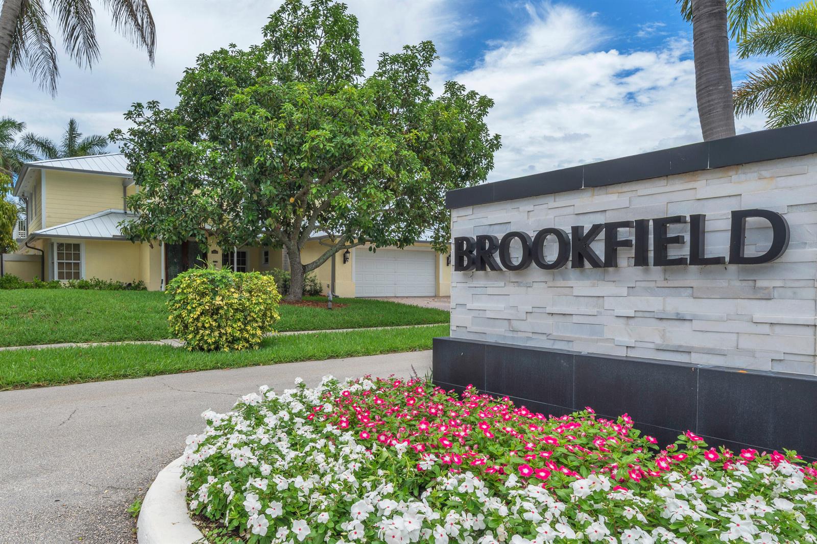 A stone sign reading BROOKFIELD stands in front of a yellow house with a lawn — 5844 Pinebrook Drive, Boca Raton FL 33433, BOCA RATON, FL