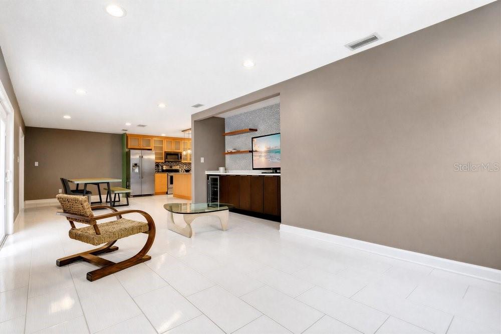 A living room with white tile floors, a wet bar, and an adjacent kitchen area — 514 BAKER STREET, ORLANDO, FL
