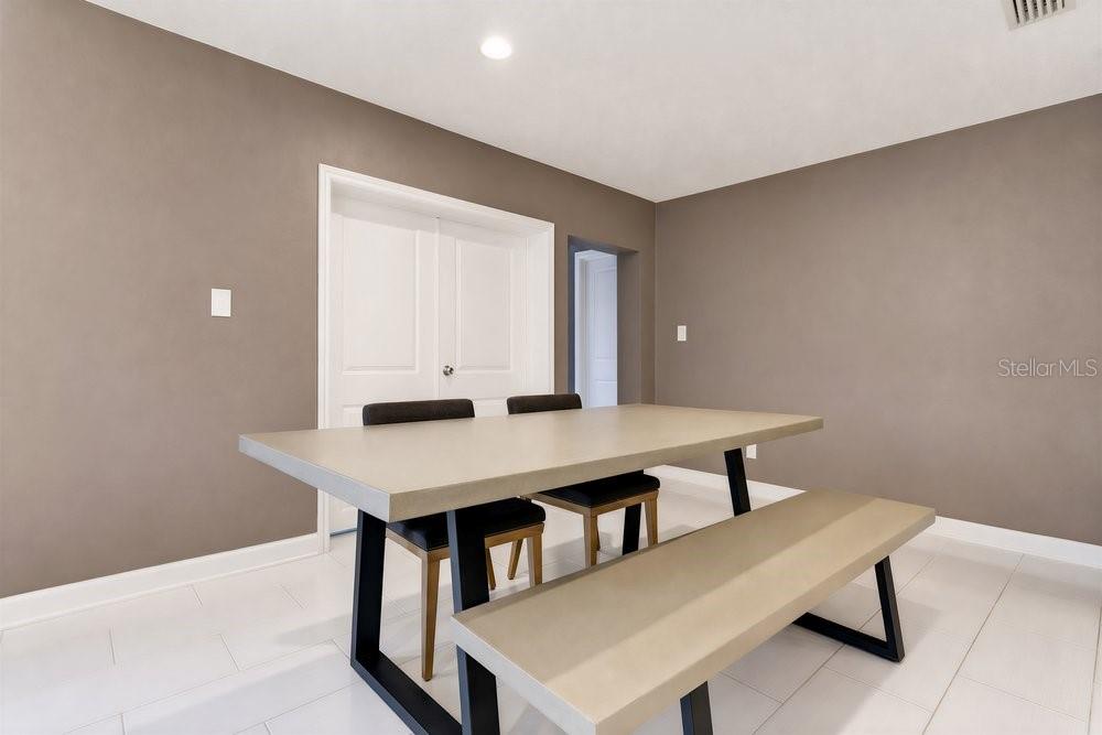 A dining room features a large rectangular table with a bench and chairs on white flooring — 514 BAKER STREET, ORLANDO, FL